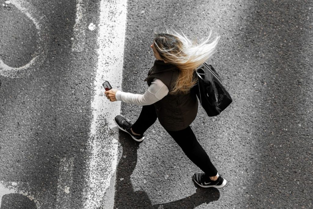 a woman jaywalking across the street