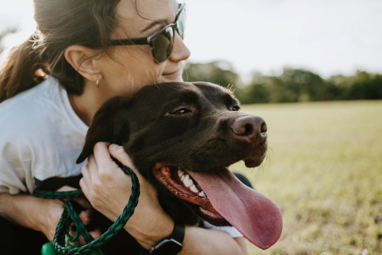 a woman outside hugging her dog