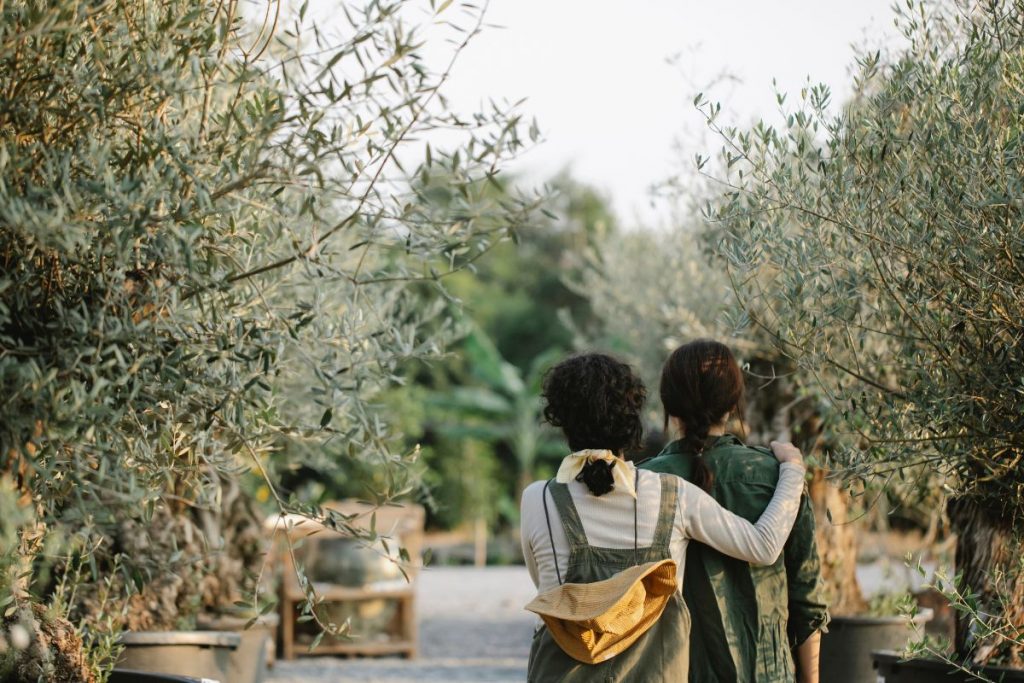 two women walking through a garden