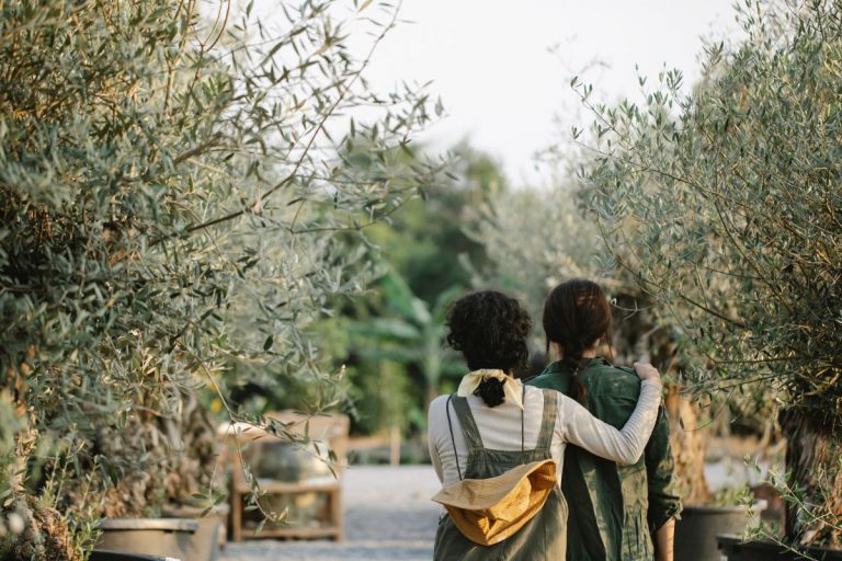 two women walking through a garden