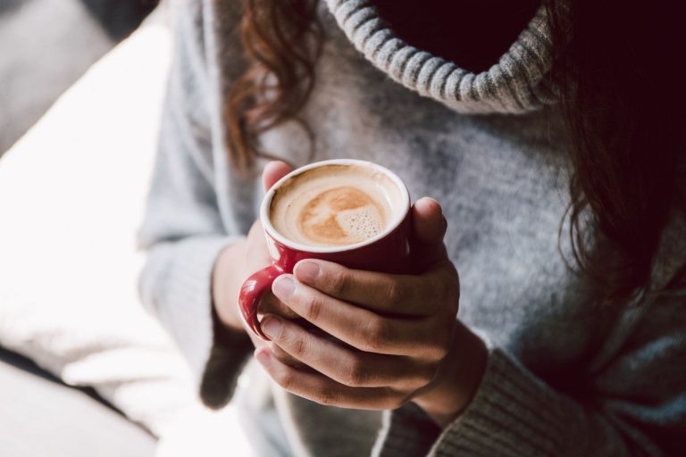 Fill my cup, oh Lord. A woman holding her full coffee cup first thing in the morning.