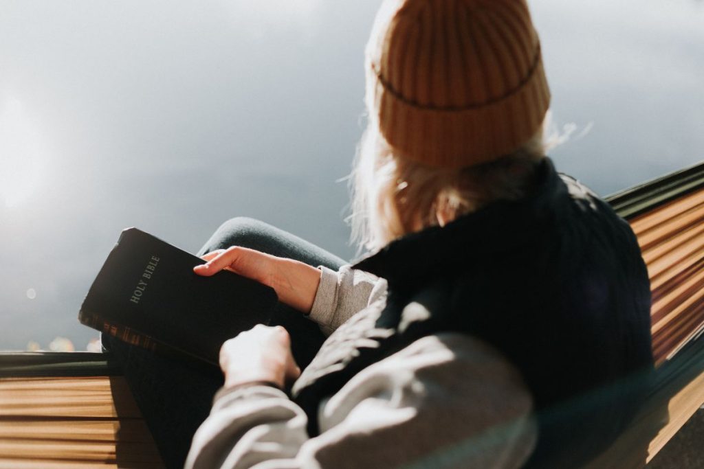 a woman holding her bible and looking out into the open