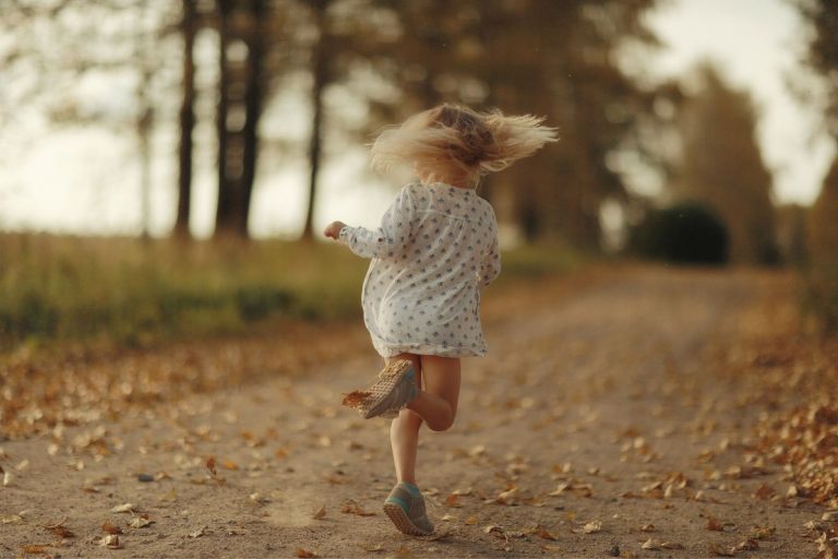blurry image of a little girl running down a lane
