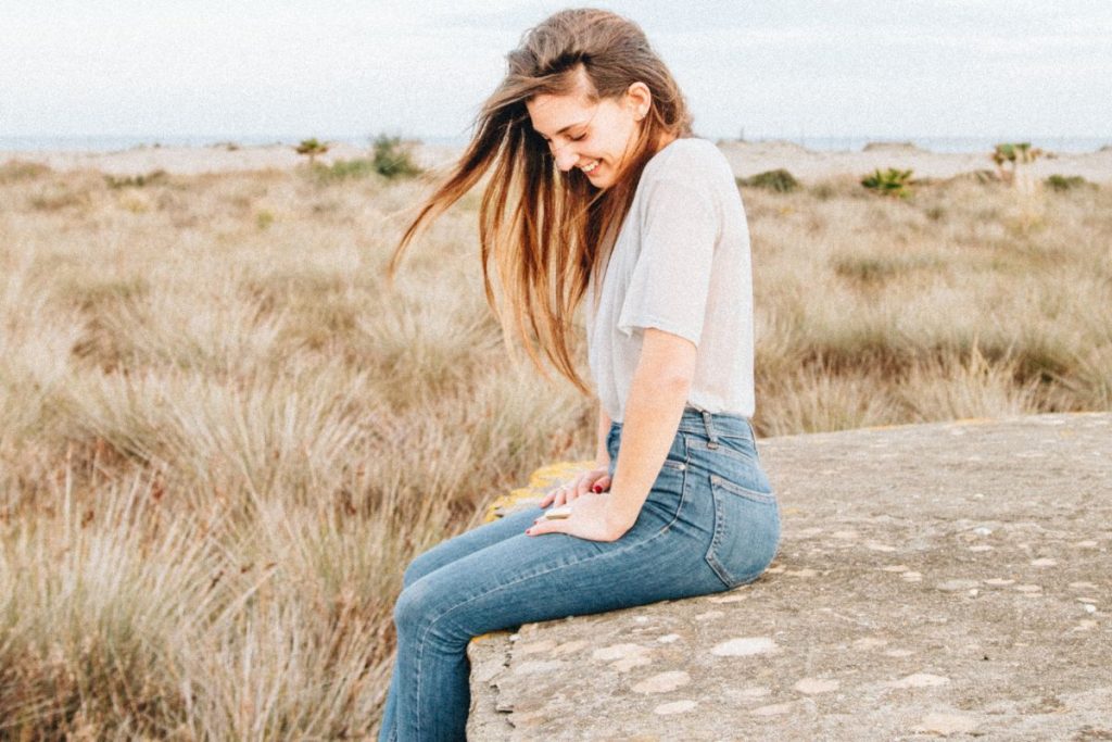 Woman sitting on a ledge smiling