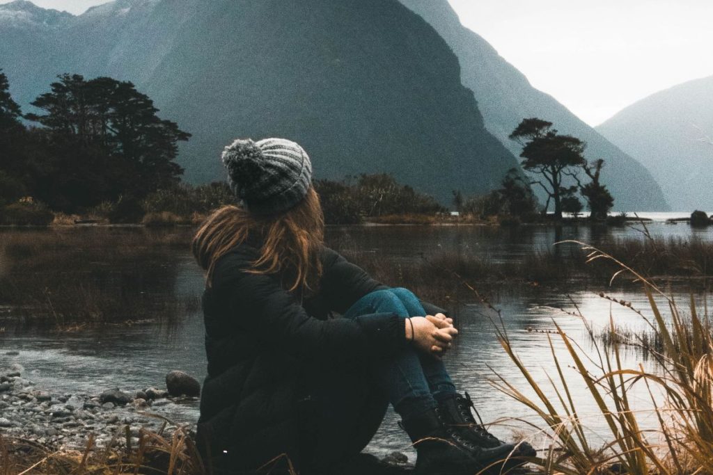 a woman staring up at the mountains in her path