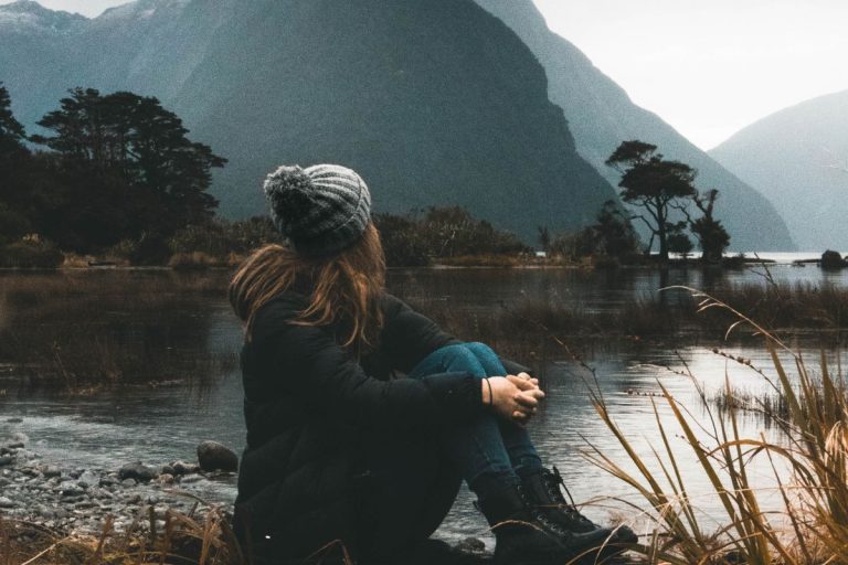 a woman staring up at the mountains in her path