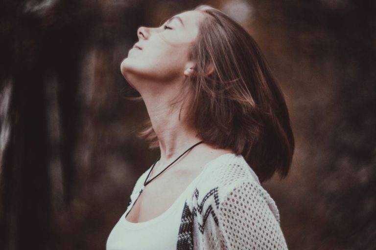 a woman with her eyes closed with her chin tilted toward the sky