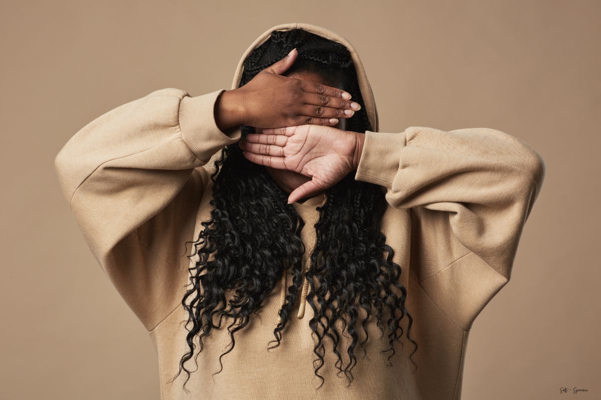 a woman hiding her face with her hands