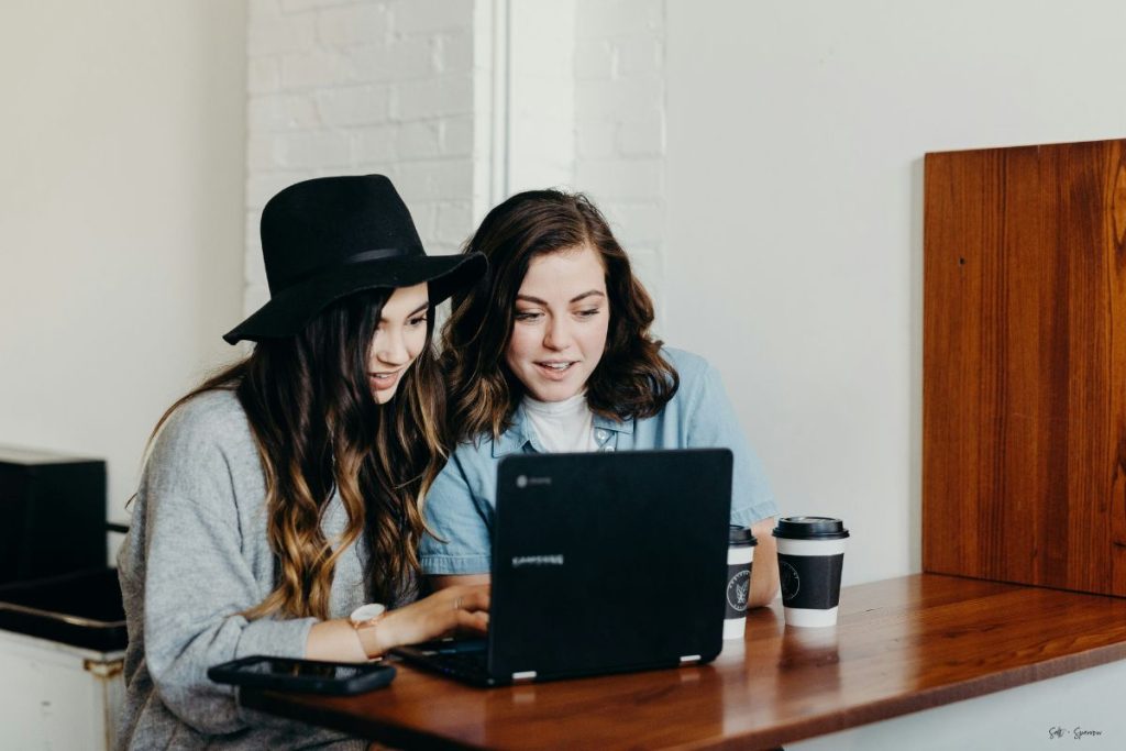 two women staring at a laptop screen together