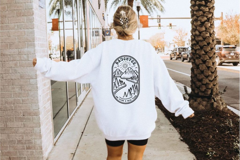 a woman walking down the streets of california with an oversized white baggy sweatshirt