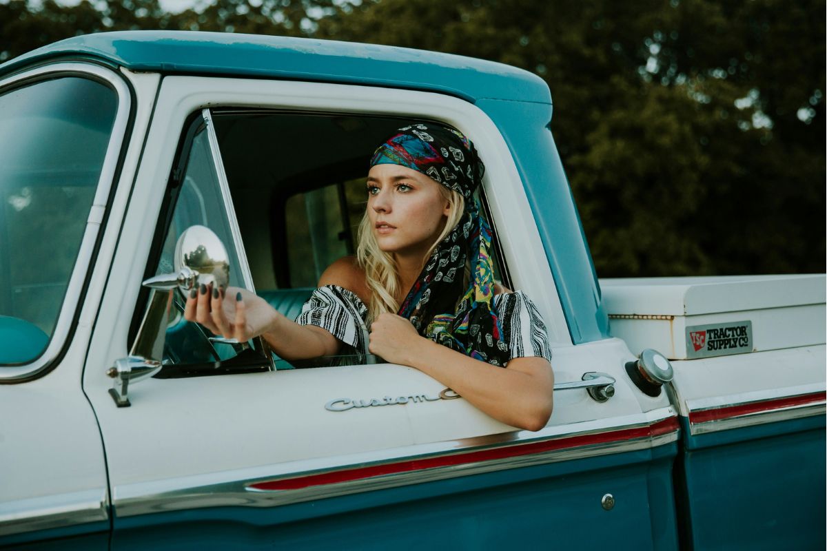 a woman sitting in a vintage pickup truck