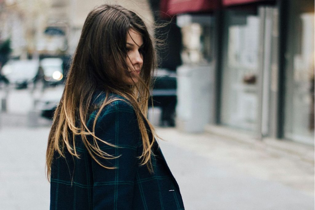 a woman turning to look back on a street