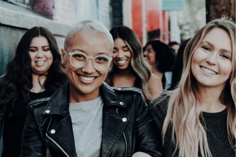 a group of women linking arms and smiling