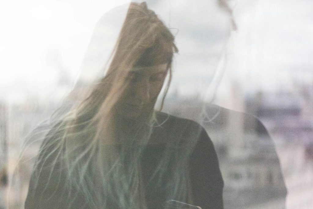 a blurry image of a woman looking down in self doubt