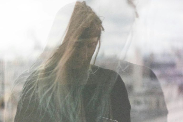 a blurry image of a woman looking down in self doubt