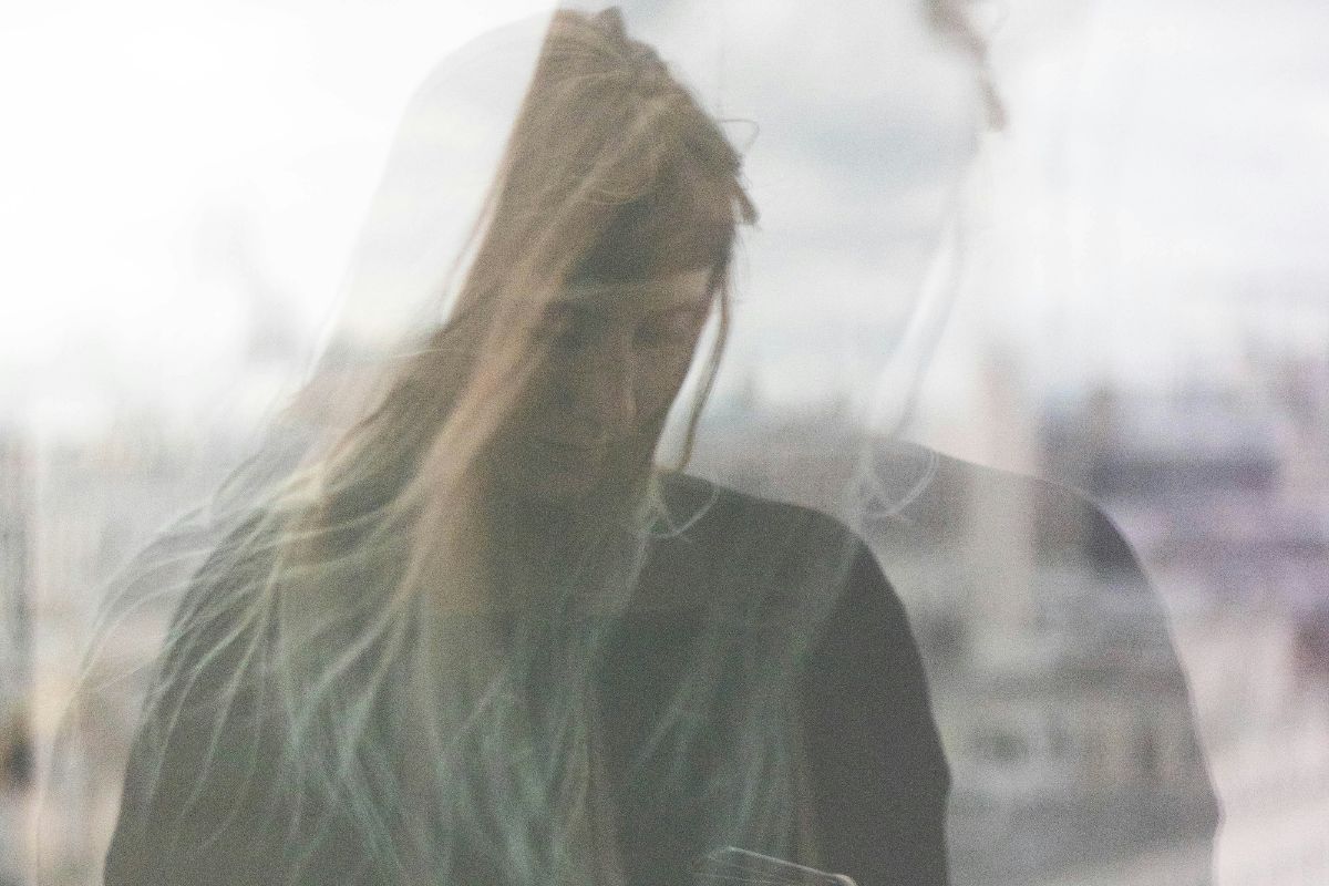 a blurry image of a woman looking down in self doubt