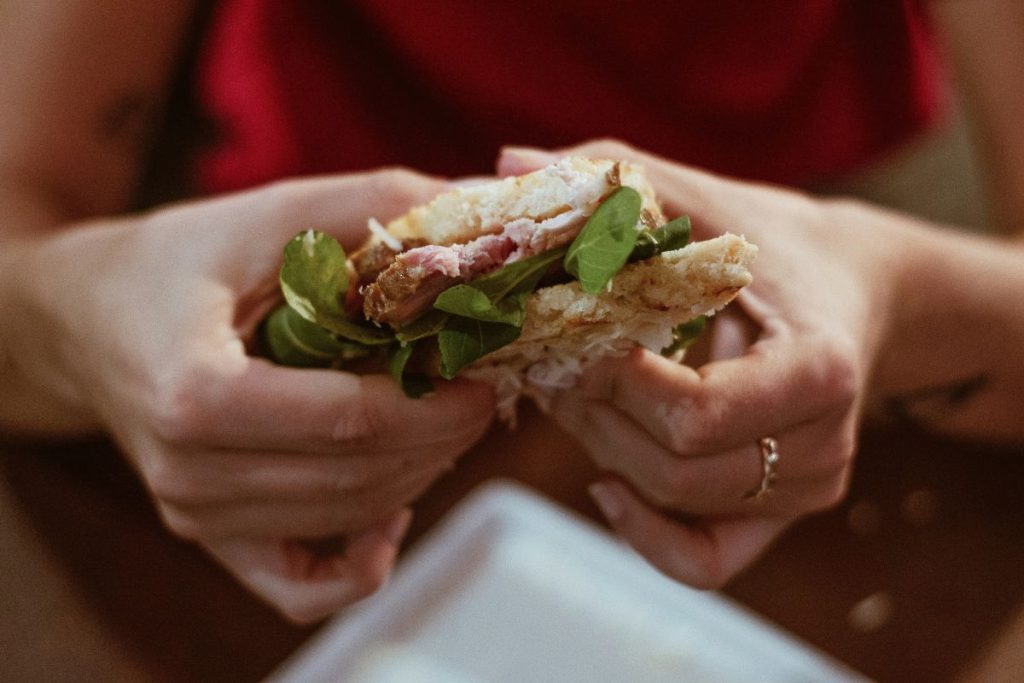 woman eating a deli meat sandwich