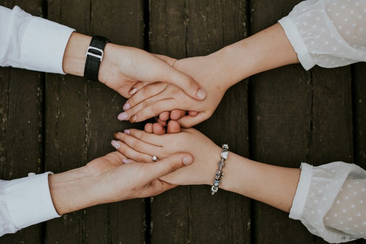 two people holding hands across a table