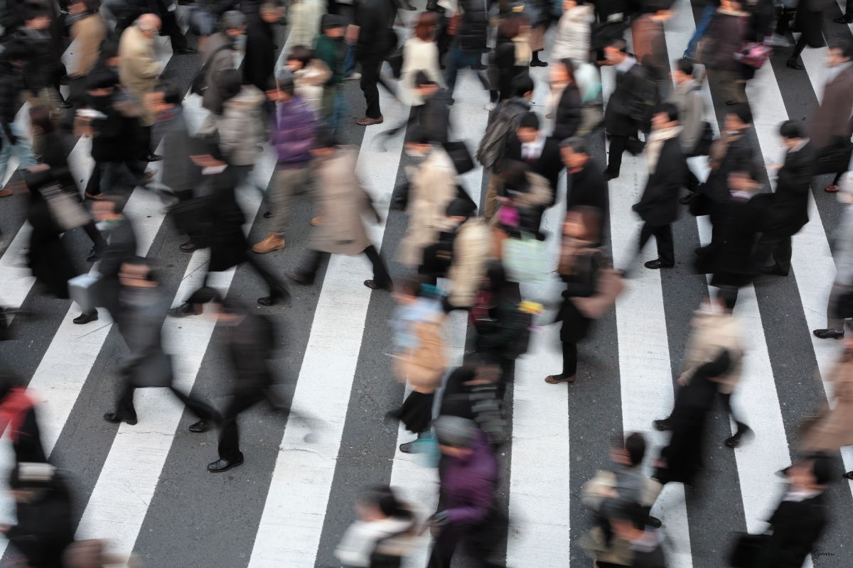 busy downtown street filled with passengers in the crosswalk