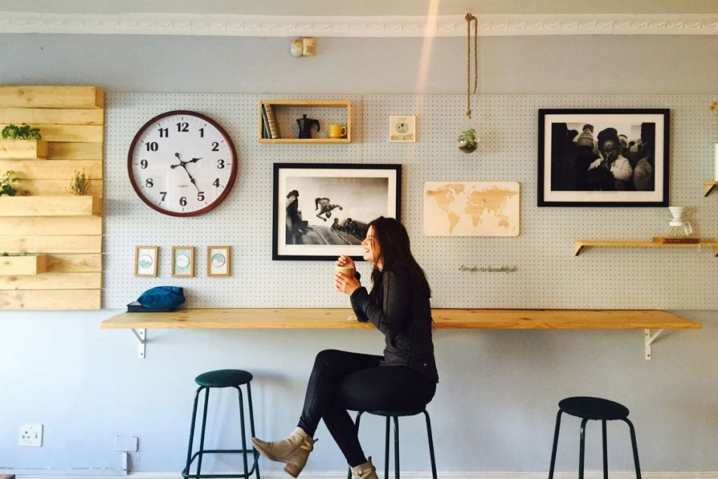 a woman sitting at a counter sipping on coffee and laughing