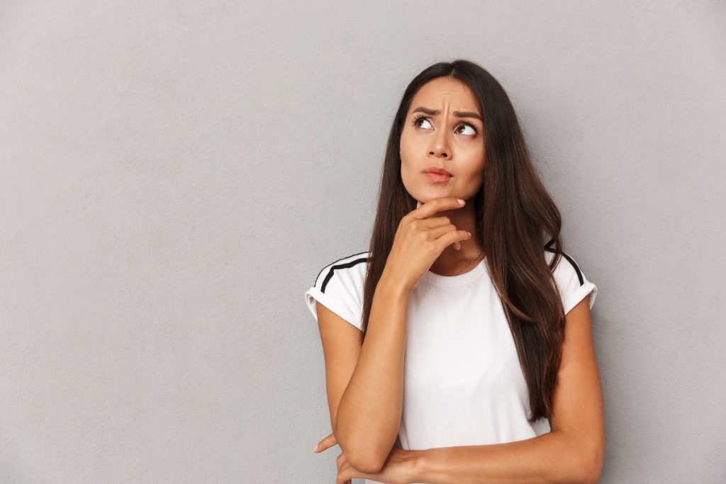 a woman resting her chin on her hand and looking upwards like she's contemplating something