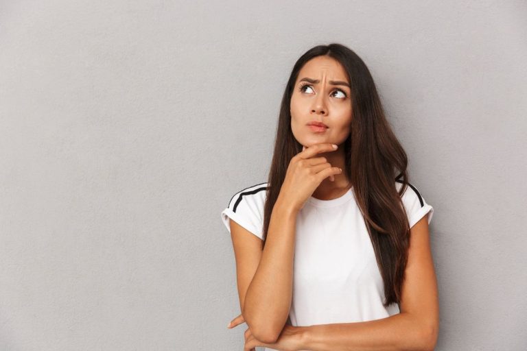 a woman resting her chin on her hand and looking upwards like she's contemplating something